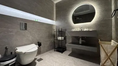 a bathroom with a toilet and a sink and a mirror at 1BDR Large Living Room Nearby Metro in Dubai