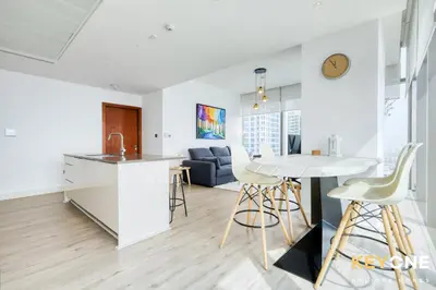 a kitchen and living room with a table and chairs at Spectacular Marina Views Luxurious Two Bedroom in Dubai
