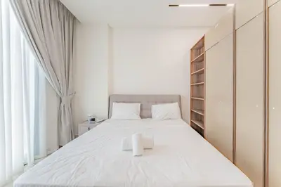 a bedroom with a large bed with a towel on it at HAVN - Studio in Binghatti Dawn, JVC in Dubai