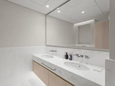 a white bathroom with a sink and a mirror at Sunset Bliss Elegant Palm Island Studio in Dubai