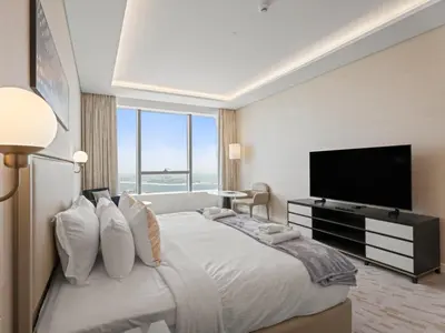 a bedroom with a large bed with a flat screen tv at Sunset Bliss Elegant Palm Island Studio in Dubai