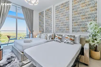 two beds in a bedroom with a large window at bnbmehomes - Skyz by Danube in Dubai