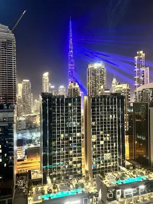 a view of a city at night with the eiffel tower at Modern 2BR I DAMAC Reva Residences I Canal Views in Dubai