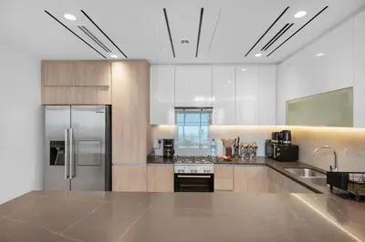 a large kitchen with a refrigerator and a sink at Spacious 3BR and Study with Multiple Ensuites Medore Residence in Dubai