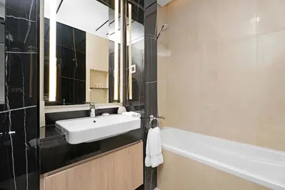 a bathroom with a sink and a bath tub at Spacious 3BR and Study with Multiple Ensuites Medore Residence in Dubai