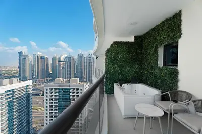 a balcony with a bathtub and chairs on a building at GuestReady - 3BR | Luxury High-Rise Escape in Dubai