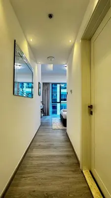 a hallway leading to a living room with a door at 4BDR Duplex Apartment 8 Guests in Dubai