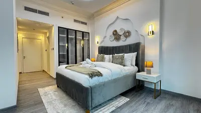 a bedroom with a large bed with a clock on the wall at 4BDR Duplex Apartment 8 Guests in Dubai
