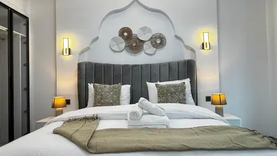 a bedroom with a large bed with a large headboard at 4BDR Duplex Apartment 8 Guests in Dubai