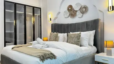 a bedroom with a large bed with a black headboard at 4BDR Duplex Apartment 8 Guests in Dubai