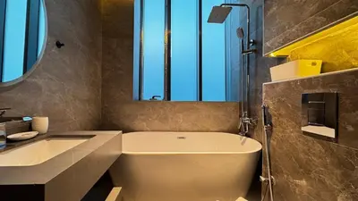 a bathroom with a white tub and a sink and a window at 3BDR Duplex Apartment with Large Family Living Room in Dubai