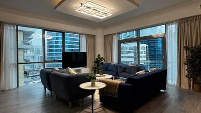 a living room with couches and a tv and large windows at 3BDR Duplex Apartment with Large Family Living Room in Dubai
