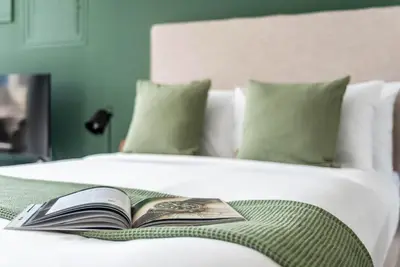 a book sitting on top of a bed at Silkhaus Studio Burj Daman with Burj Khalifa View in Dubai