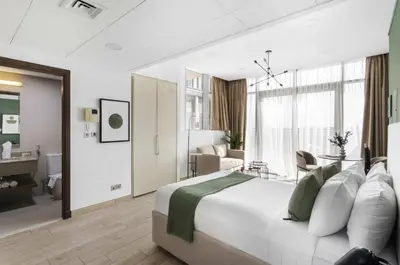 a bedroom with a large bed and a living room at Silkhaus Studio Burj Daman with Burj Khalifa View in Dubai