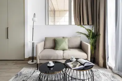 a living room with a couch and a table at Silkhaus Studio Burj Daman with Burj Khalifa View in Dubai