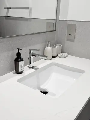 a bathroom sink with a soap dispenser and a mirror at Oshima Grande Downtown 1BR Burj Khalifa in Dubai