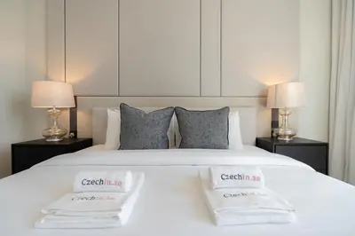 a bedroom with a white bed with two towels on it at Elegant 1BR LIV Marina Dubai World-Class Amenities in Dubai