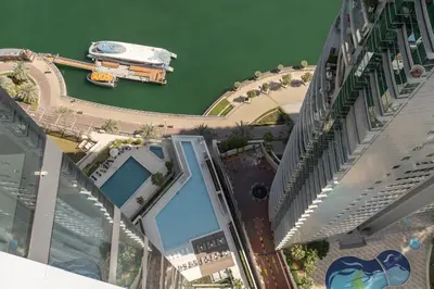 arial view of a building with a boat in the water at Elegant 1BR LIV Marina Dubai World-Class Amenities in Dubai
