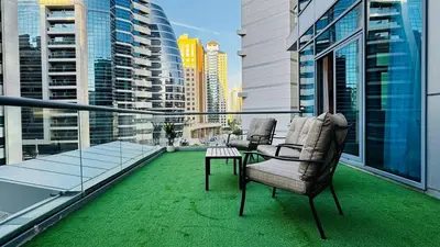 a balcony with two chairs and a table on top of a building at 1 Bedroom centrally located with large balcony in Dubai