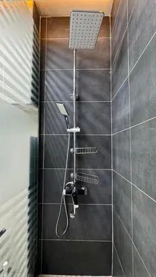 a shower with a shower head on a tiled wall at 1 Bedroom centrally located with large balcony in Dubai