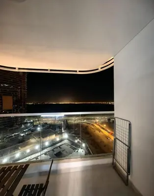 a balcony with a view of a city at night at Modern Studio in Opalz - Ideal for Work & Leisure in Dubai
