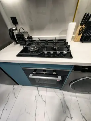 a stove top oven in a white counter top at Modern Studio in Opalz - Ideal for Work & Leisure in Dubai