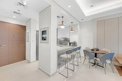 a kitchen and dining room with a table and chairs at Nobles Tower- Luxe with Skies-High 1BR Lifestyle in Dubai