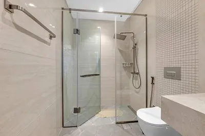 a glass shower in a bathroom with a toilet at Nobles Tower- Luxe with Skies-High 1BR Lifestyle in Dubai