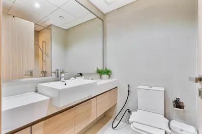 a bathroom with a sink and a toilet and a mirror at Chic Studio at Azizi Riviera Near Downtown Dubai in Dubai