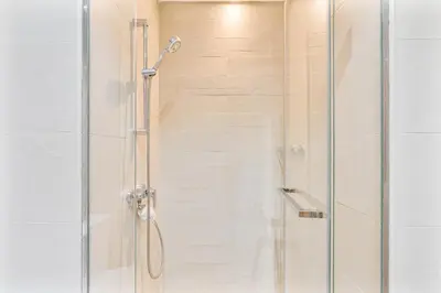 a shower with a glass door in a bathroom at Chic Studio at Azizi Riviera Near Downtown Dubai in Dubai