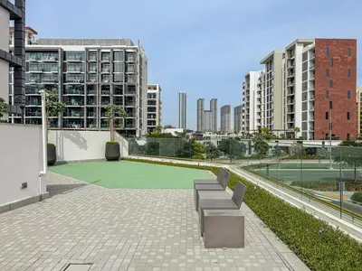 a tennis court with benches in a city at Chic Studio at Azizi Riviera Near Downtown Dubai in Dubai