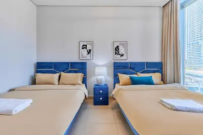 two beds in a room with blue and white at Luxury Apartments Near Burj Khalifa in Downtown in Dubai
