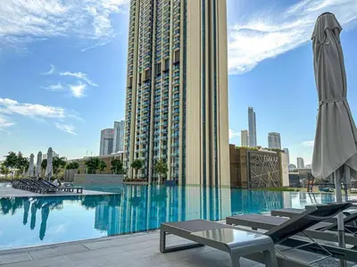 a swimming pool with chairs and a large building at Luxury Apartments Near Burj Khalifa in Downtown in Dubai