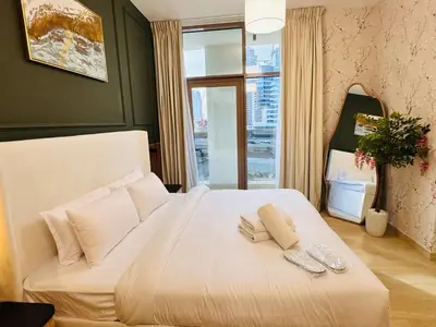 a bedroom with a white bed with two napkins on it at Celestial 2BR with Burj Khalifa View in Dubai