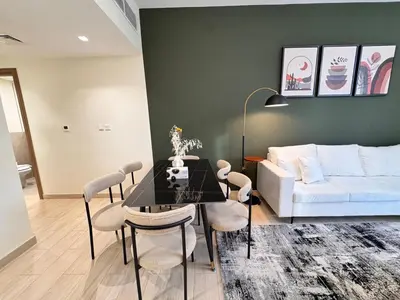 a living room with a couch and a table and chairs at Celestial 2BR with Burj Khalifa View in Dubai