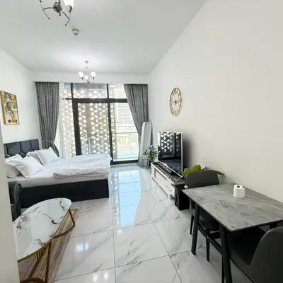 a living room with a bed and a table at An elegant sanctuary in Dubai