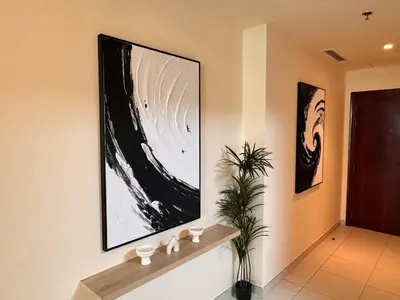 a hallway with two paintings on the wall with a plant at Skylux Bright 1BR with Canal Views & Extra Bed in Dubai