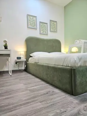a bedroom with a large bed and a table at Green Zen Studio Metro 15 mins walk away in Dubai