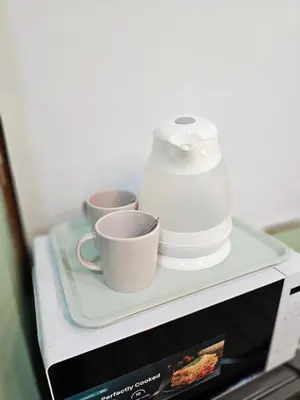 a microwave with two cups and a blender on a shelf at Green Zen Studio Metro 15 mins walk away in Dubai