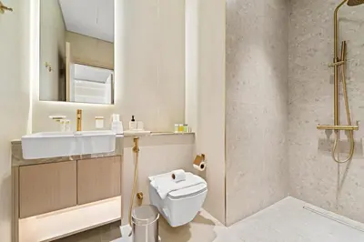 a bathroom with a toilet and a sink and a shower at Luxe 1BR in JVC with Private Jacuzzi & Pool Access in Dubai