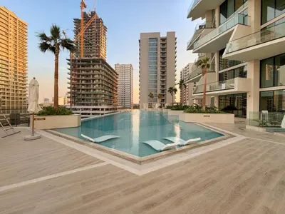 a swimming pool in the middle of a city with buildings at Luxe 1BR in JVC with Private Jacuzzi & Pool Access in Dubai