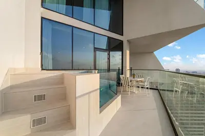 a balcony of a building with a table and chairs at Luxe 1BR in JVC with Private Jacuzzi & Pool Access in Dubai