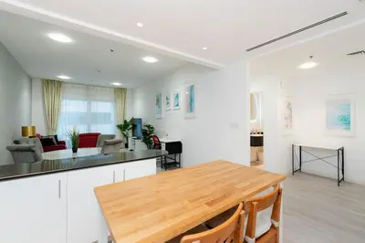 a kitchen and living room with a wooden table at Lovely beach life 1 bed apartment in Dubai Marina in Dubai