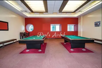 two pool tables in a room with red walls at Lovely beach life 1 bed apartment in Dubai Marina in Dubai