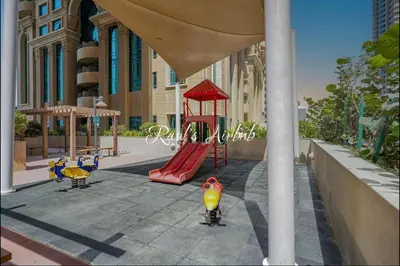 a playground with a red slide and a red swing at Lovely beach life 1 bed apartment in Dubai Marina in Dubai