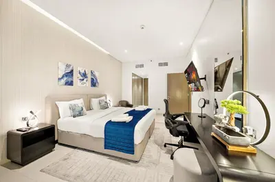 a bedroom with a bed and a desk with a computer at Luxe 1BR with Balcony & Canal View in Dubai