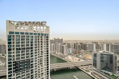 a view of a city with a river and buildings at Luxe 1BR with Balcony & Canal View in Dubai