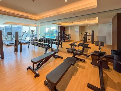 a gym with a bunch of treadmills and machines at Frank Porter - J One Tower in Dubai