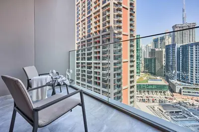 a chair on a balcony with a view of a city at Frank Porter - Peninsula One in Dubai