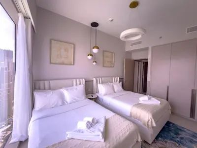 a bedroom with two beds with towels on them at GRANDE SIGNATURE RESIDENCES direct Burj Khalifa view and Private Fountain Show at high floor with DXB AIRPORT VIP Shuttle option in Dubai